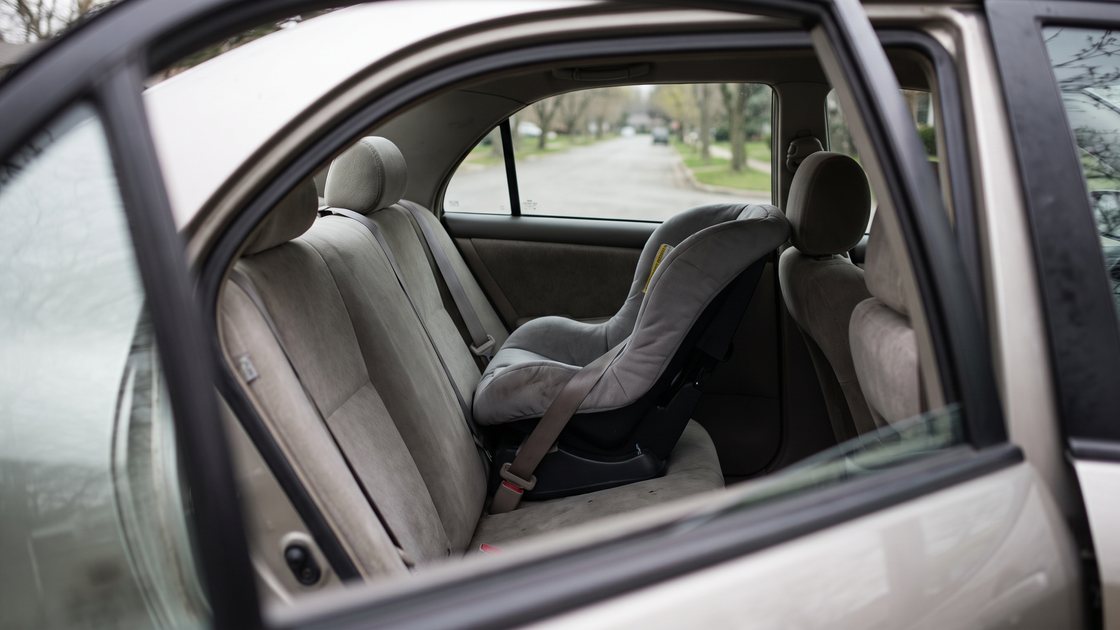 An empty child safety seat installed in the back seat of a car